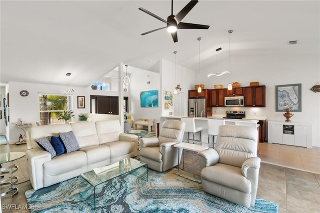 living area featuring light tile patterned floors, high vaulted ceiling, visible vents, and a ceiling fan