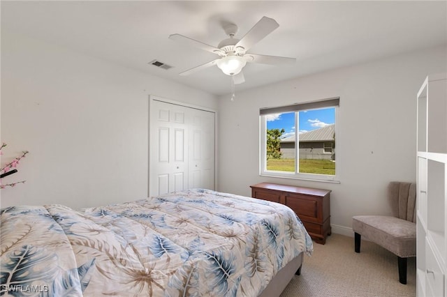 bedroom with ceiling fan, light colored carpet, visible vents, baseboards, and a closet