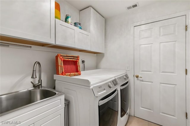 laundry room with visible vents, cabinet space, a sink, and washer and clothes dryer