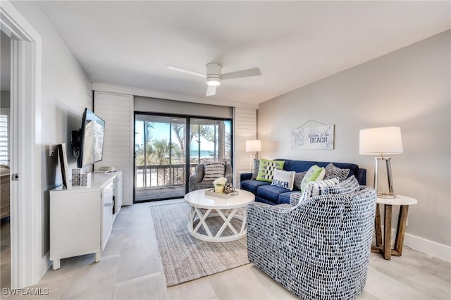 living area with a ceiling fan and baseboards