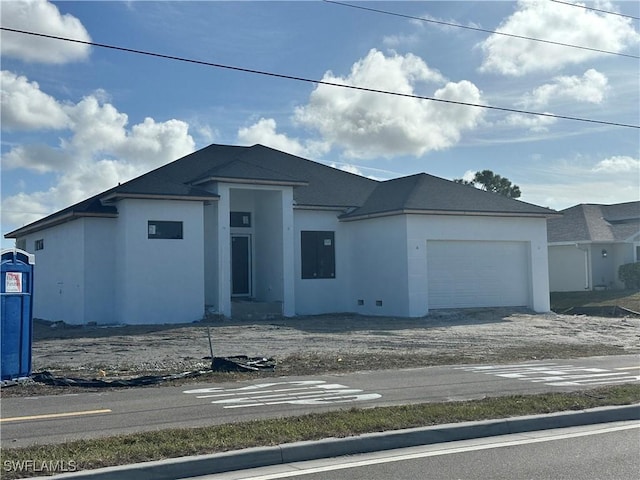 view of front of property featuring a garage, driveway, and stucco siding