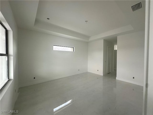 unfurnished room with visible vents and a raised ceiling