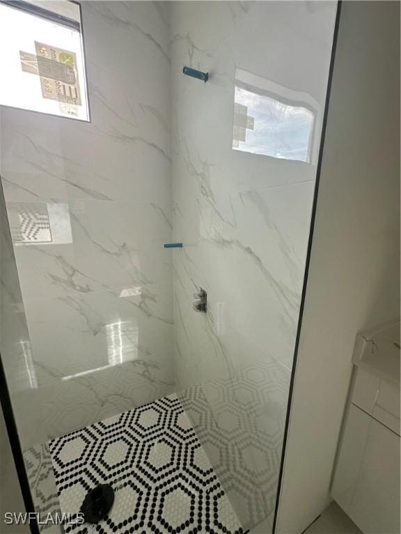 full bath with a marble finish shower