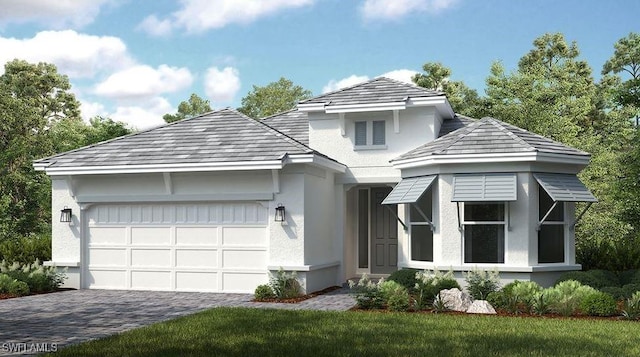 view of front of house featuring an attached garage, a front yard, decorative driveway, and stucco siding