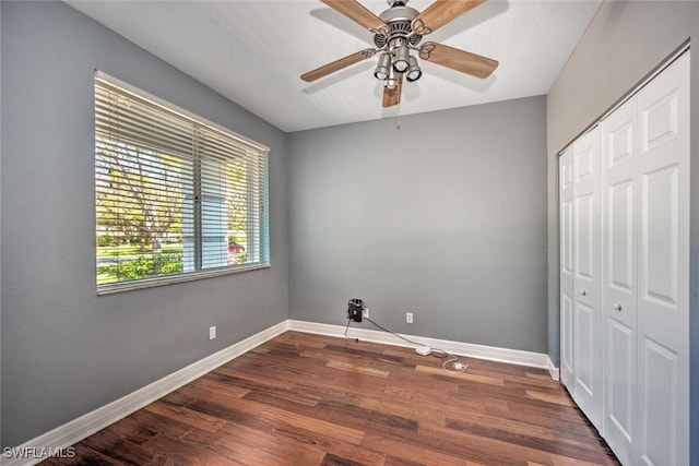 bedroom with a ceiling fan, a closet, dark wood finished floors, and baseboards