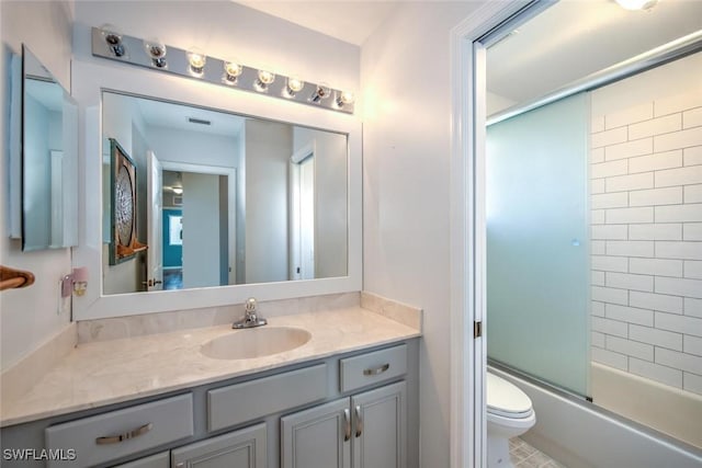 bathroom featuring vanity, toilet, and bath / shower combo with glass door