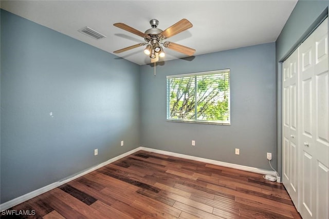 unfurnished bedroom with baseboards, visible vents, a ceiling fan, wood finished floors, and a closet