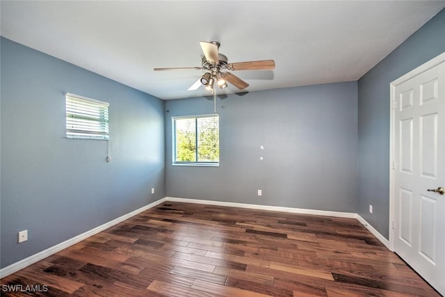 unfurnished room with dark wood-style flooring, ceiling fan, and baseboards