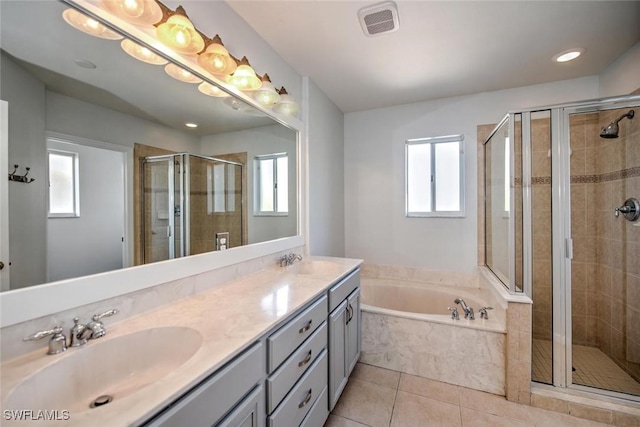 bathroom with a stall shower, a garden tub, and a sink