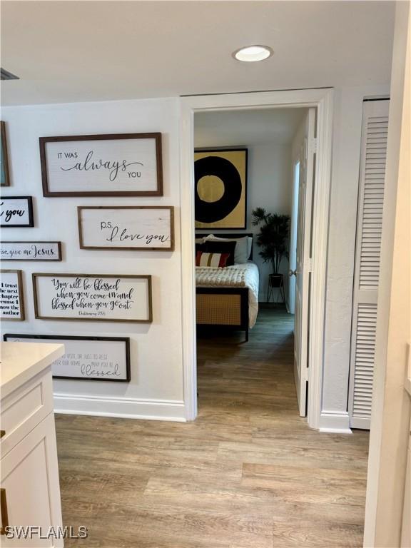 hallway with light wood finished floors and baseboards