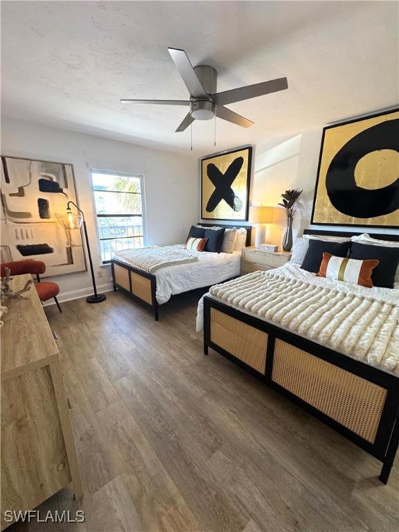 bedroom with baseboards, a ceiling fan, and dark wood-type flooring