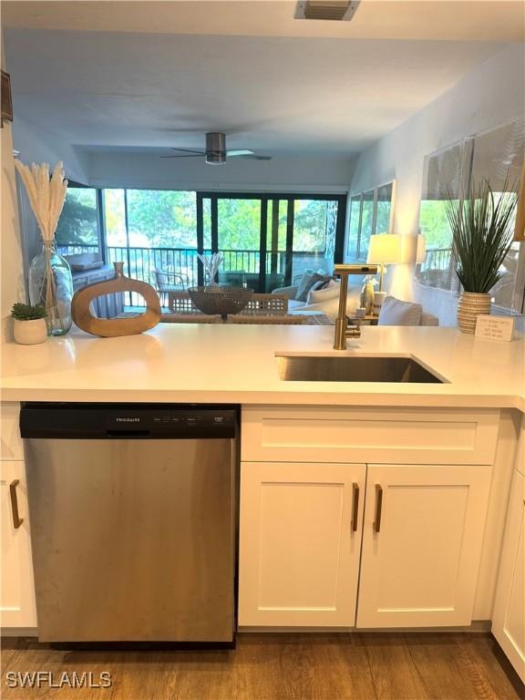 kitchen featuring white cabinets, light countertops, and dishwasher