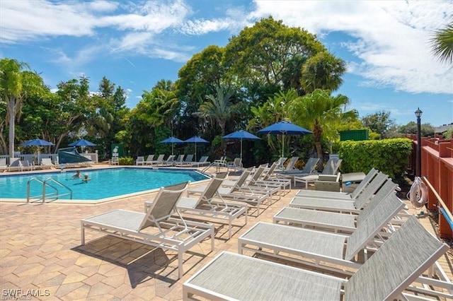 pool with a patio and fence