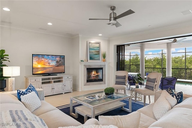 living area with ornamental molding, ceiling fan, and a healthy amount of sunlight
