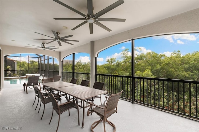 sunroom featuring a ceiling fan and outdoor dining space