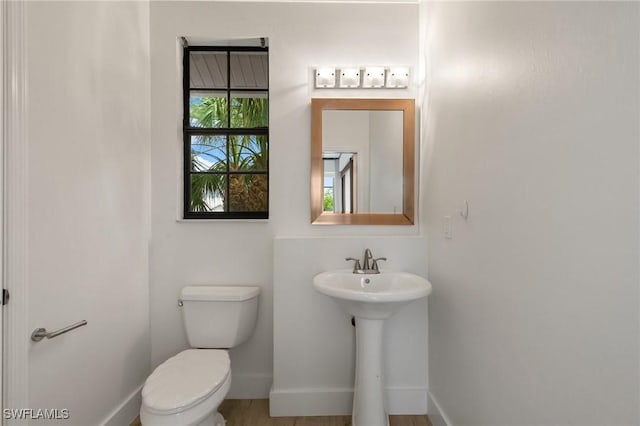 bathroom with baseboards and toilet