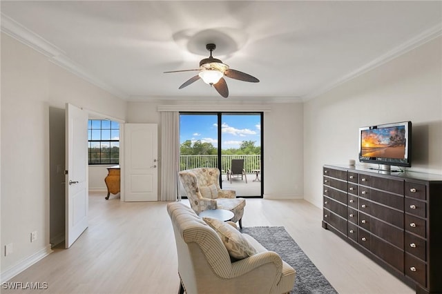 sitting room featuring baseboards, light wood-style flooring, ornamental molding, and ceiling fan