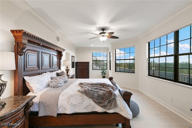 bedroom featuring light wood-style flooring, baseboards, visible vents, a ceiling fan, and ornamental molding