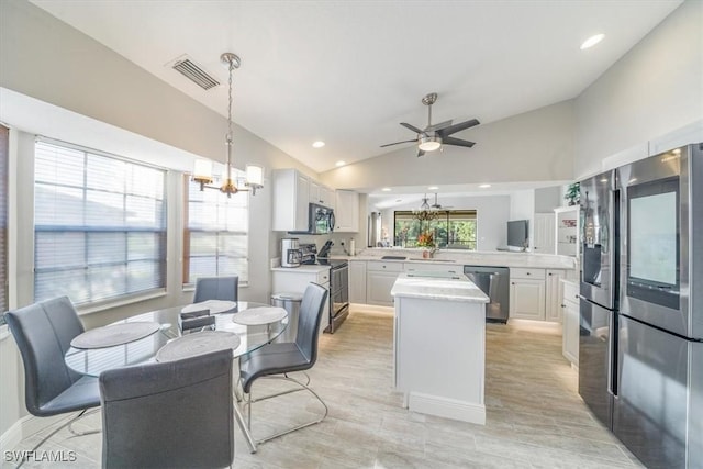 kitchen featuring visible vents, lofted ceiling, appliances with stainless steel finishes, a peninsula, and light countertops