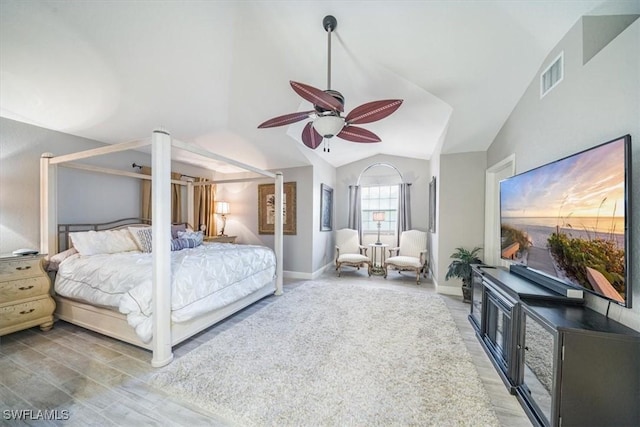 bedroom with lofted ceiling, a ceiling fan, visible vents, baseboards, and light wood finished floors