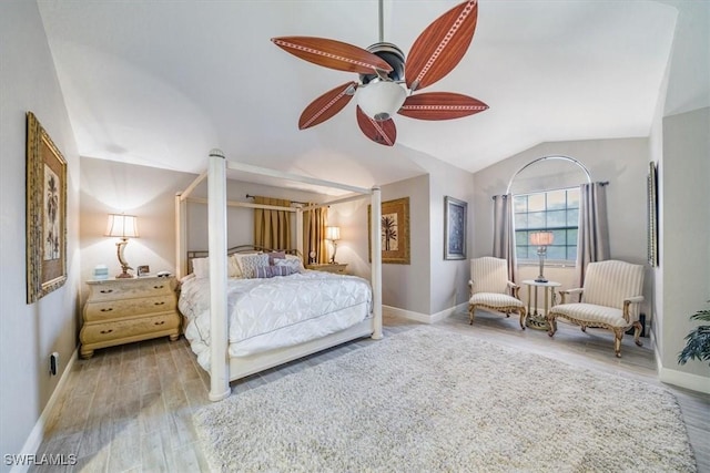 bedroom featuring a ceiling fan, lofted ceiling, baseboards, and wood finished floors