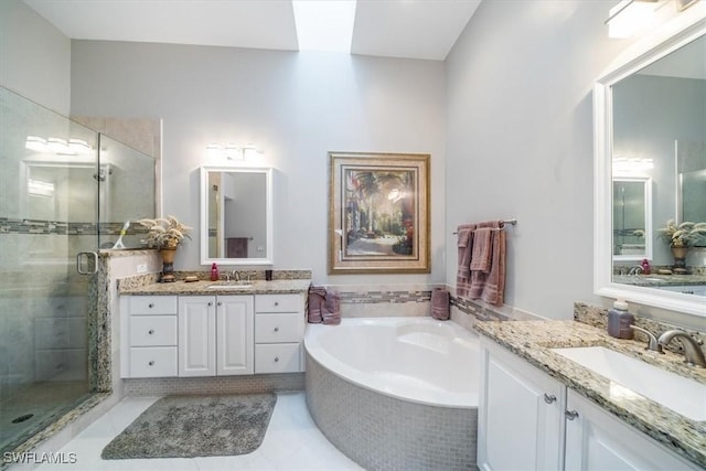 full bathroom with a bath, a shower stall, two vanities, and a sink