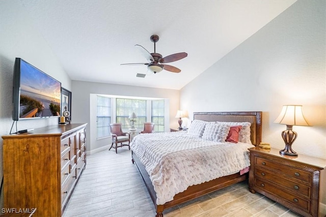 bedroom featuring baseboards, visible vents, a ceiling fan, lofted ceiling, and light wood-type flooring