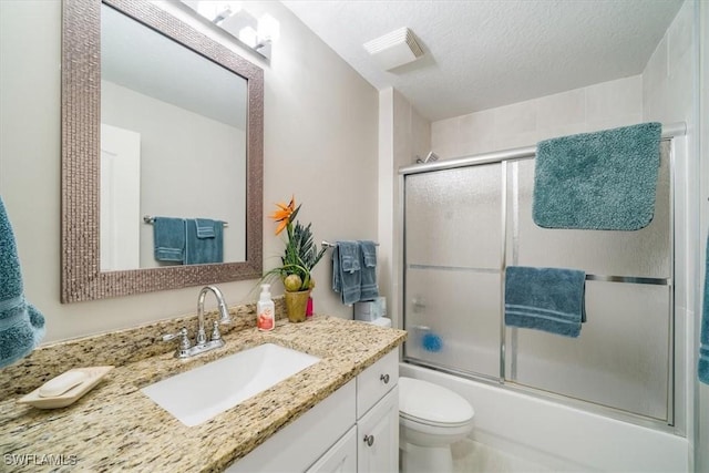 full bath with a textured ceiling, enclosed tub / shower combo, toilet, visible vents, and vanity