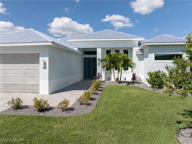 view of front of property with decorative driveway, a front yard, an attached garage, and stucco siding