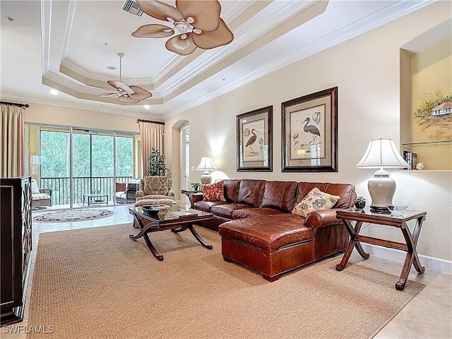 living room with arched walkways, visible vents, a ceiling fan, ornamental molding, and a raised ceiling