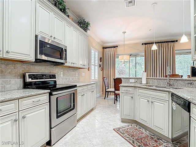 kitchen with light tile patterned flooring, visible vents, ornamental molding, appliances with stainless steel finishes, and backsplash