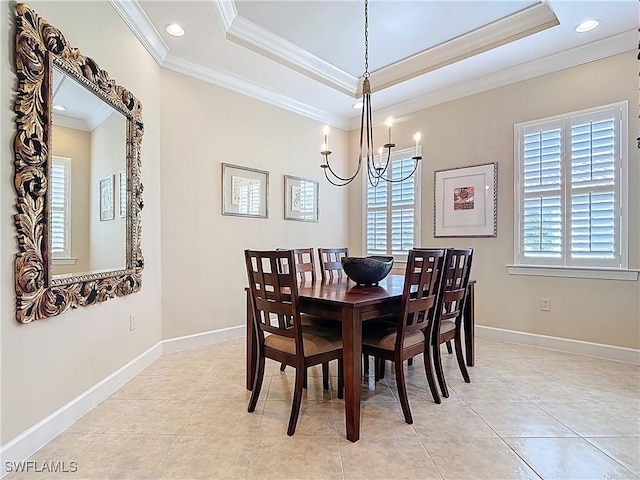 dining room featuring baseboards, ornamental molding, and a raised ceiling