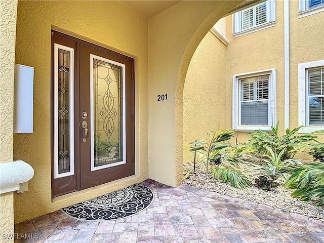 doorway to property featuring stucco siding