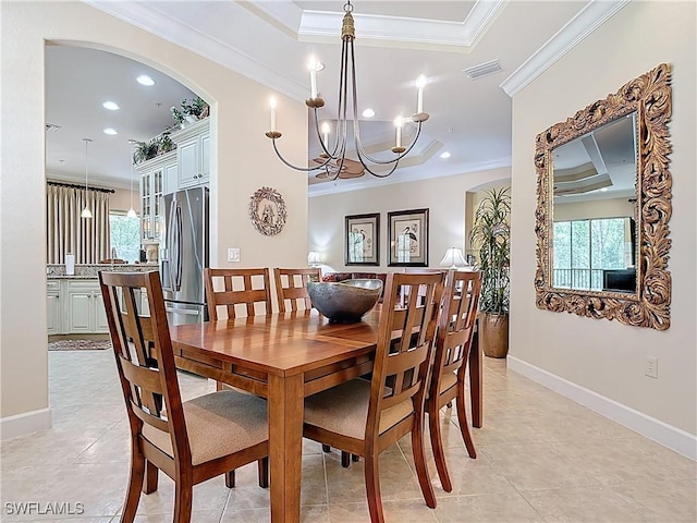 dining area featuring a tray ceiling, a healthy amount of sunlight, crown molding, and visible vents