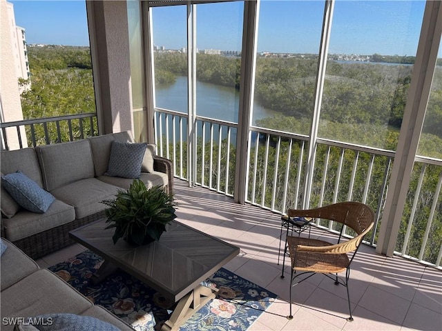 sunroom featuring a water view