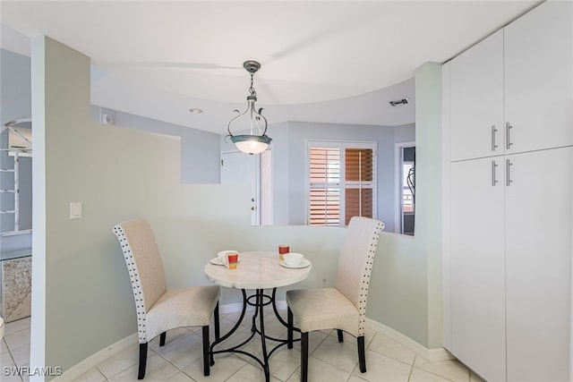 dining space featuring light tile patterned floors, visible vents, and baseboards