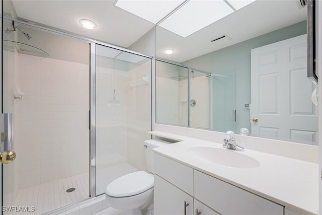 bathroom featuring a shower stall, toilet, and vanity