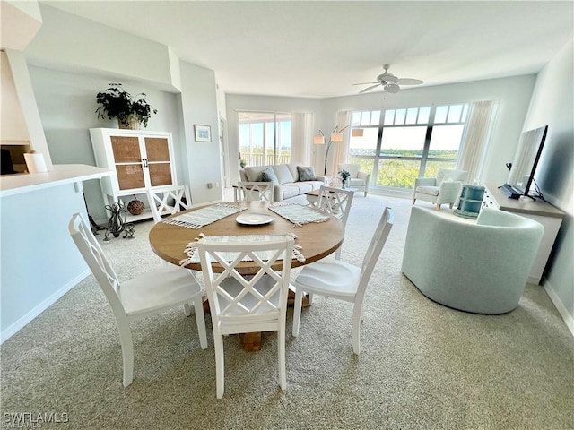 carpeted dining room featuring ceiling fan and baseboards