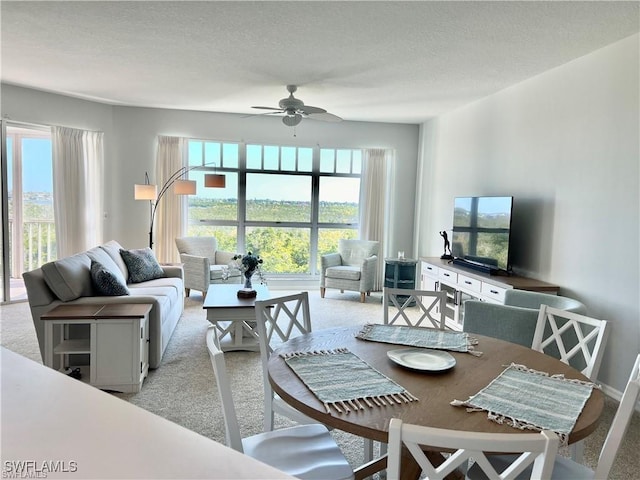 living area featuring light carpet, a healthy amount of sunlight, and ceiling fan