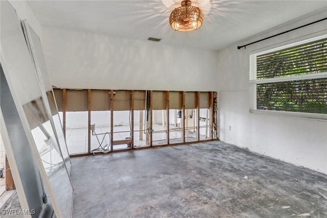 spare room featuring concrete floors and visible vents