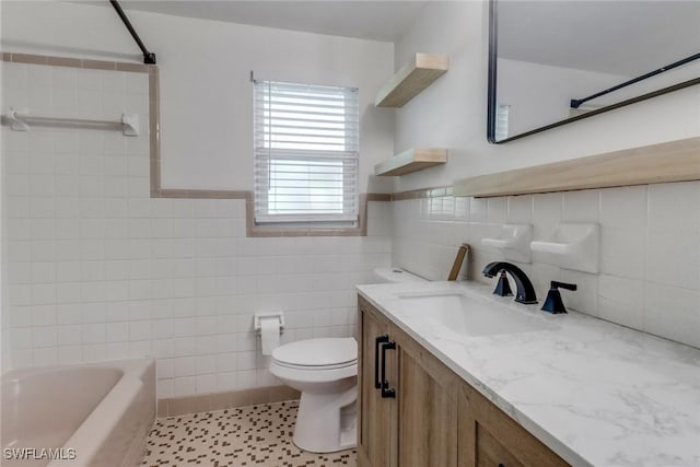 bathroom with shower / tub combination, toilet, vanity, tile walls, and wainscoting