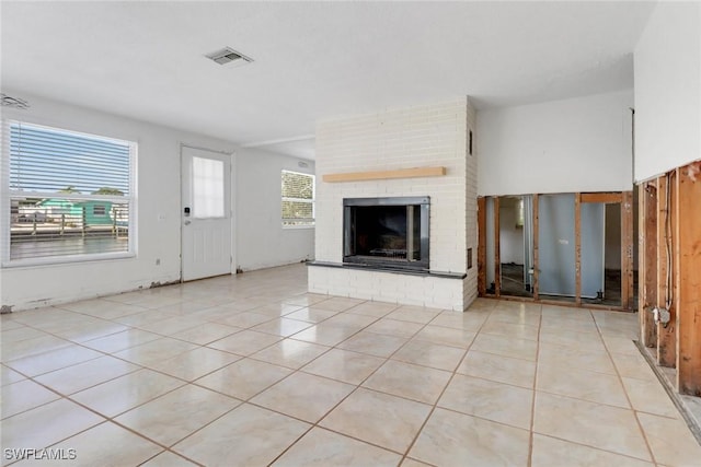 unfurnished living room featuring visible vents, a fireplace, and light tile patterned flooring