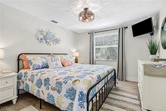 bedroom with light wood-type flooring, baseboards, and visible vents