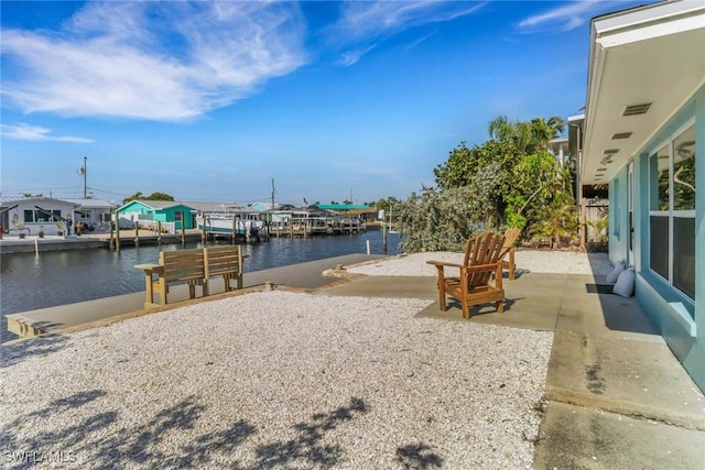 dock area featuring a water view and a patio