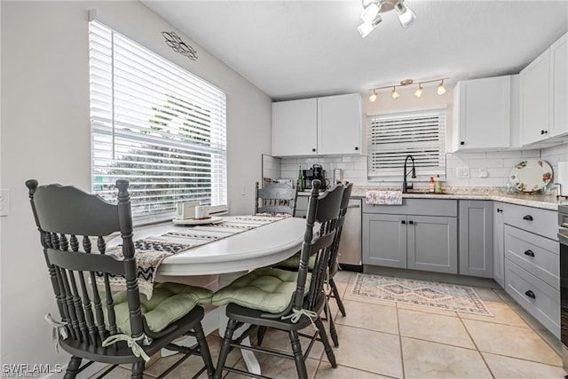 kitchen with light tile patterned floors, tasteful backsplash, white cabinetry, and gray cabinetry