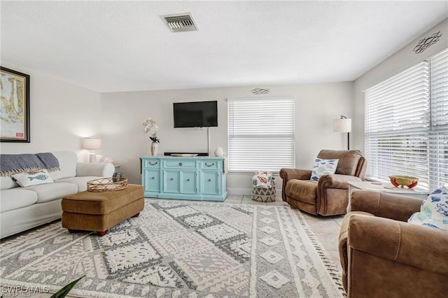 living area featuring light tile patterned flooring and visible vents