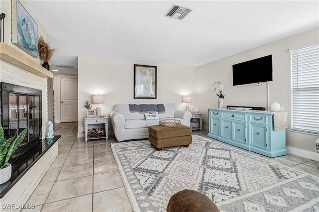 living area featuring baseboards, a fireplace, visible vents, and light tile patterned flooring