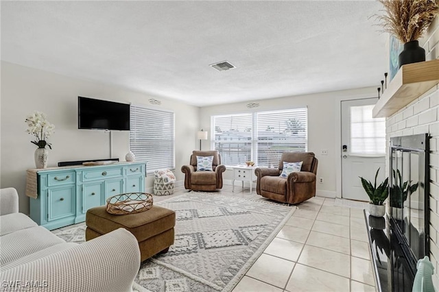 living room with light tile patterned floors, baseboards, and visible vents