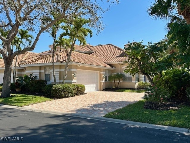 view of front of home with a garage, decorative driveway, stucco siding, and a tile roof