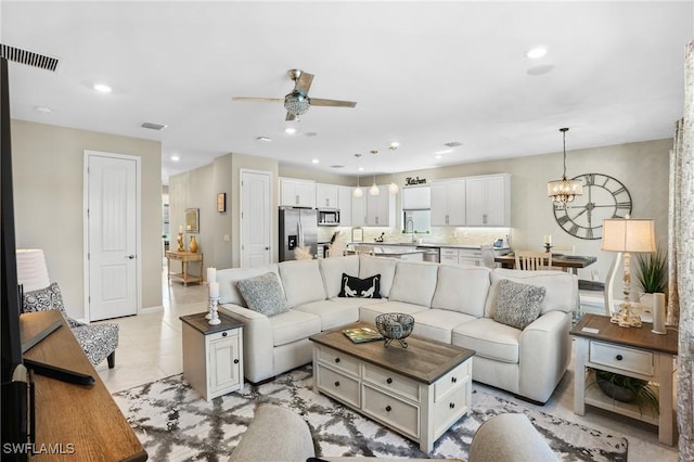 living room with ceiling fan with notable chandelier, recessed lighting, visible vents, and baseboards